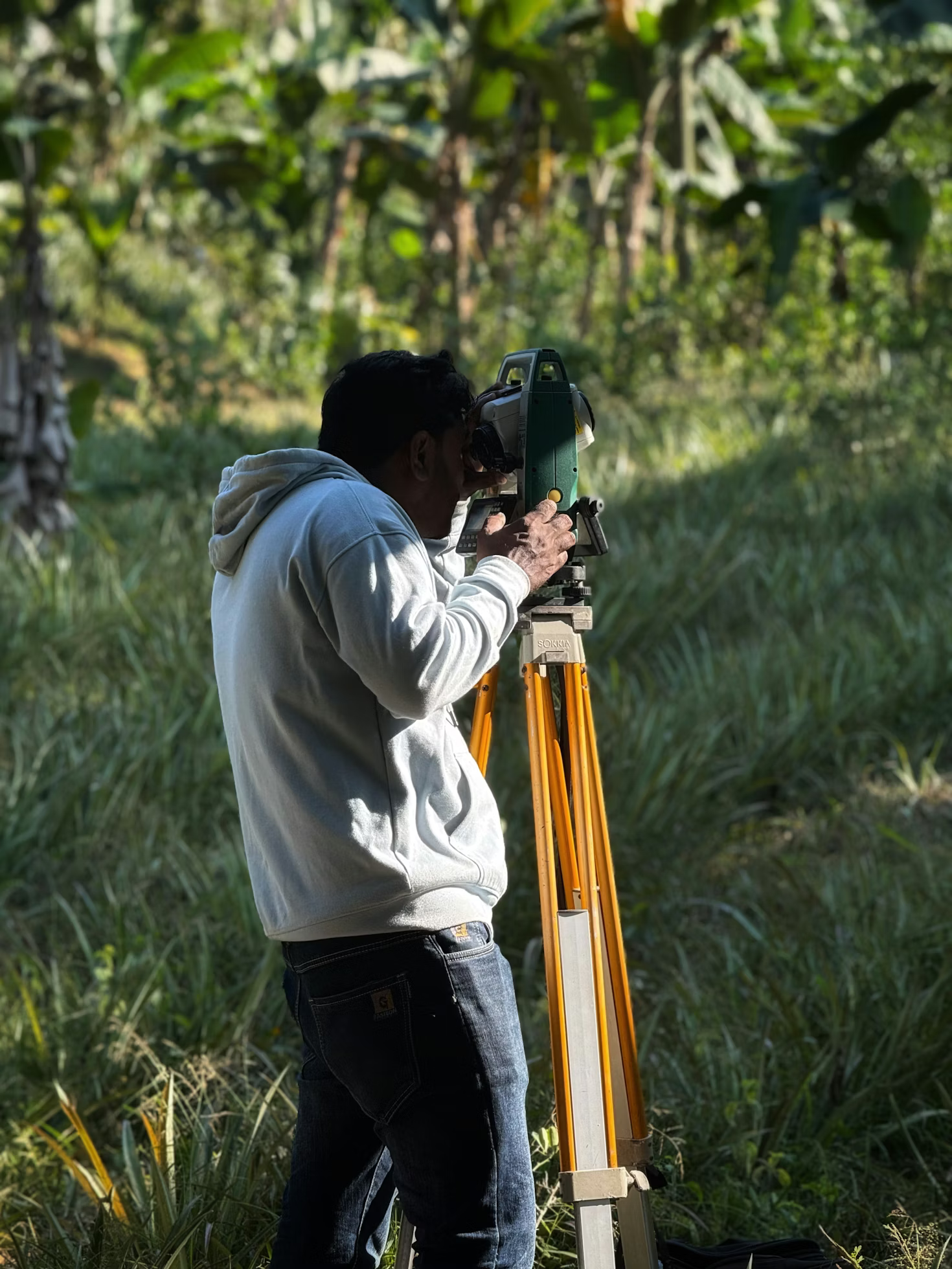 Land surveyor using surveying equipment in the field